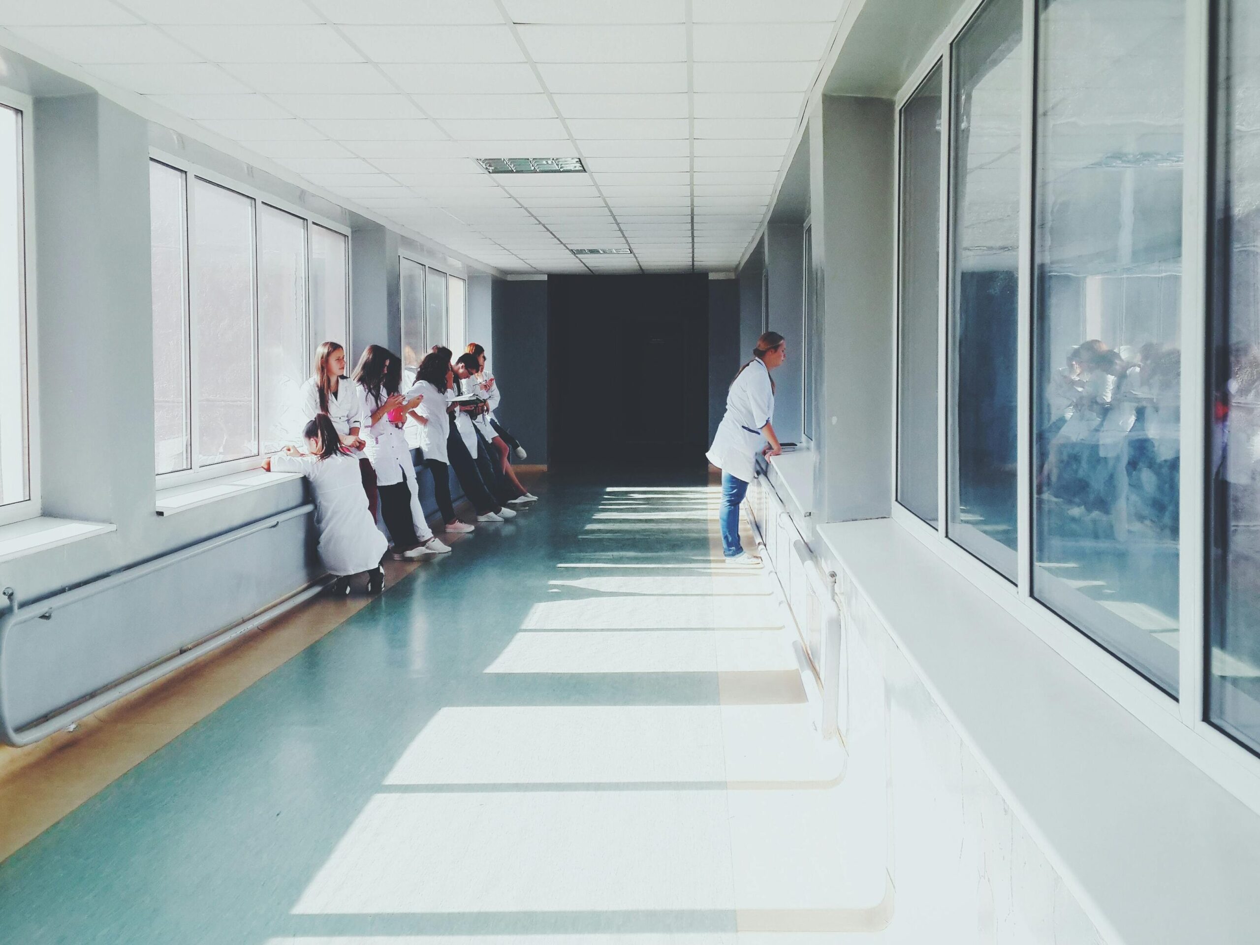 Couloir lumineux d’un hôpital avec du personnel médical en blouse blanche